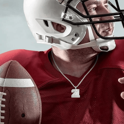  football player wearing a helmet and red jersey, holding a football, and showing a Stainless Steel number pendant with "21" and the name "Logan" engraved on it.