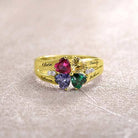 Gold ring with four heart-shaped gems in various colors, engraved with names "Olivia," "Rebecca," "Sandy," "Joshua."