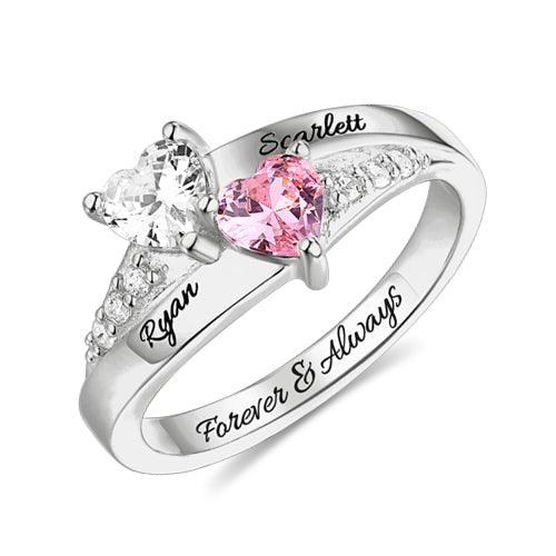 A personalized heart birthstone ring with engraved names "Ryan" and "Scarlett," featuring two heart-shaped stones and sparkling crystal accents in sterling silver.