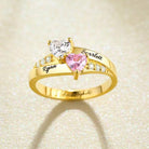 A personalized heart birthstone ring in gold plating with engraved names "Ryan" and "Scarlett," featuring heart-shaped stones and sparkling crystal accents.