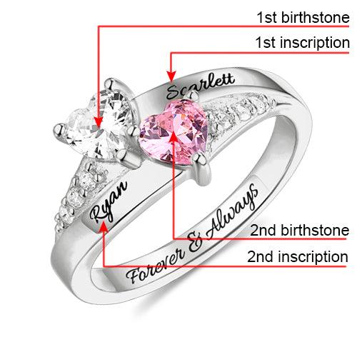 A personalized heart birthstone ring in sterling silver with labeled birthstones and inscriptions: 1st birthstone (clear), 1st inscription (Scarlett), 2nd birthstone (pink), 2nd inscription (Ryan), and "Forever & Always".