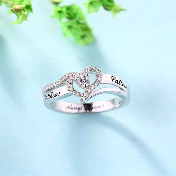 Engraved silver ring with diamond heart, names 'Matthew' and 'Fatima', and 'Always & Forever' on blue background.