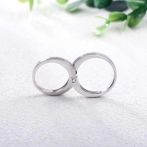 Sterling silver couple rings set forming an infinity symbol when joined, featuring embedded stones. Elegant design representing eternal love and unity.