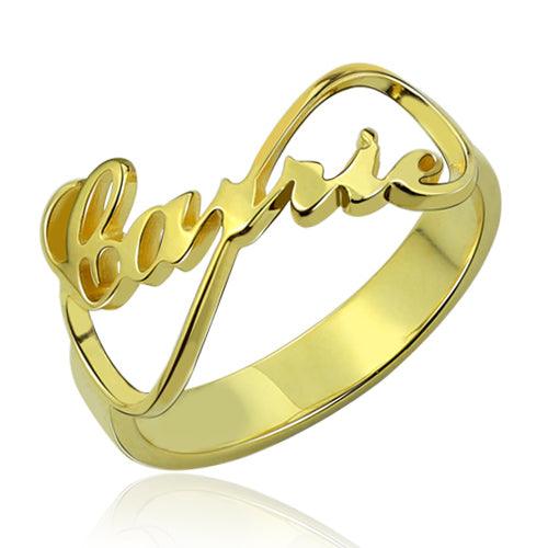 Gold ring with the word "Carrie" written in cursive script, forming an infinity symbol design.