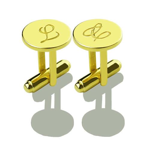 Pair of gold cufflinks with monogrammed initials 'L' and intertwined 'L' displayed on a reflective surface.