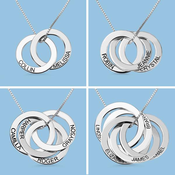 Four personalized interlocking circle necklaces with engraved names on silver rings, showcasing different name combinations and ring arrangements on a blue background.