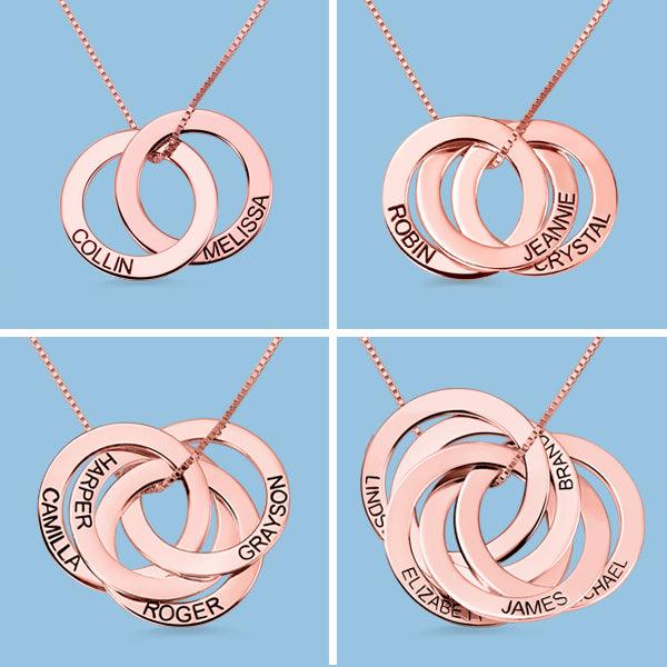 Four rose gold interlocking circle necklaces with names engraved: "COLLIN MELISSA," "ROBIN JEANNIE CRYSTAL," "HARPER ROGER CAMILLA GRAYSON," and "LINDSAY ELIZABETH JAMES MICHAEL BRANDON."