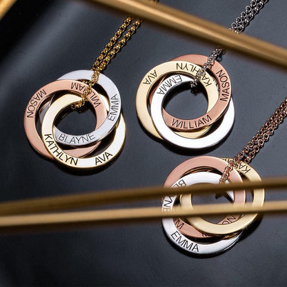 Three necklaces with interlocking rings in rose gold, silver, and gold, each engraved with names: MASON, WILLIAM, EMMA, KATHLYN, AVA, and BLAYNE.