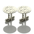 Pair of silver monogram cufflinks with 'ABC' initials, shown on a reflective surface.