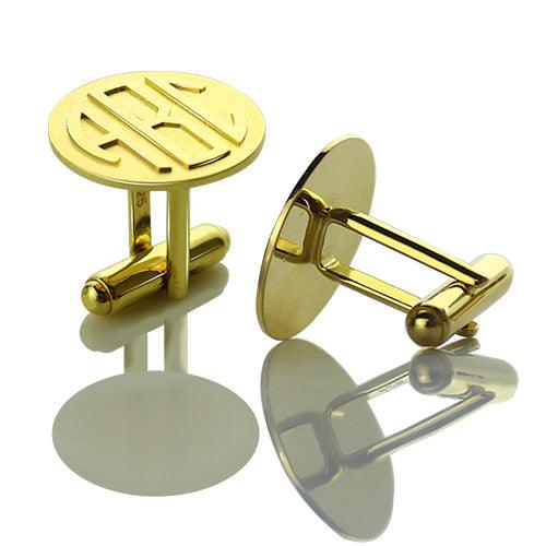 Gold monogram cufflinks with 'ABC' initials, displayed on a reflective surface.