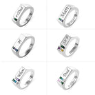 Collection of six personalized silver rings, each featuring names, initials, and colorful gemstones.