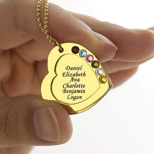 A hand holding a gold heart-shaped pendant with the names Daniel, Elizabeth, Ava, Charlotte, Benjamin, and Logan engraved on it, adorned with colorful gemstones.