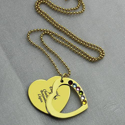 Gold heart pendant with cutout, engraved names, and colorful gems on a chain.