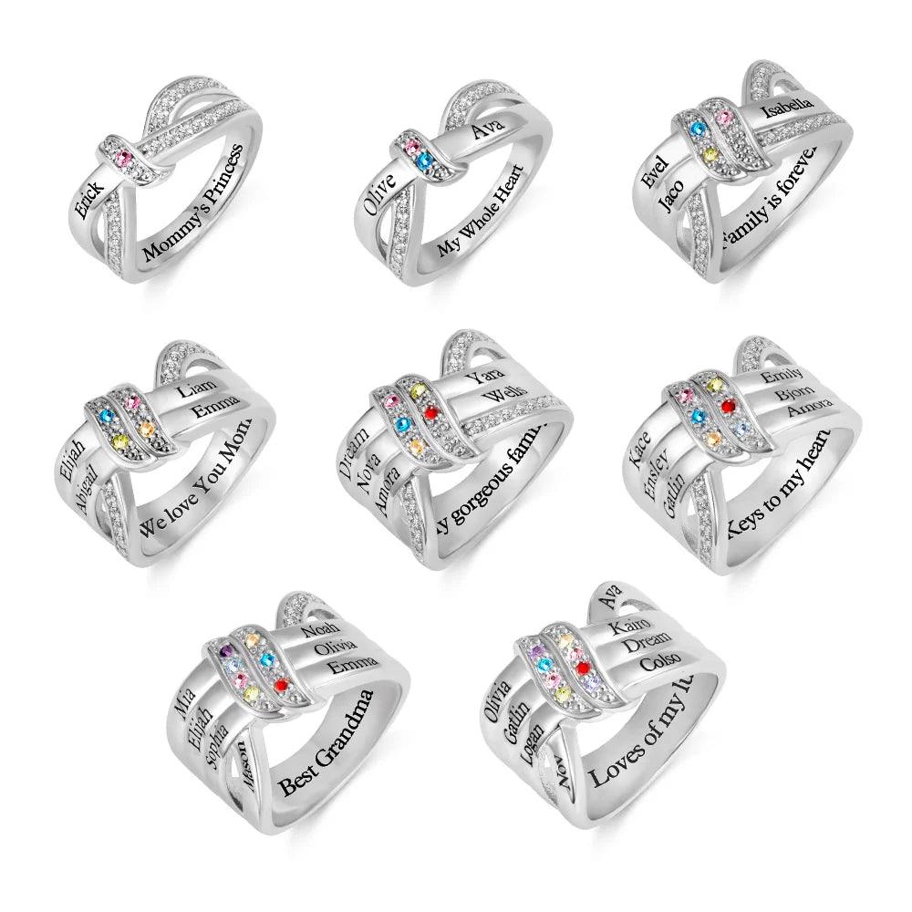 Eight silver intertwined rings with engraved names and colorful gemstones, featuring phrases like "My Whole Heart," "Family is forever," and "Best Grandma."