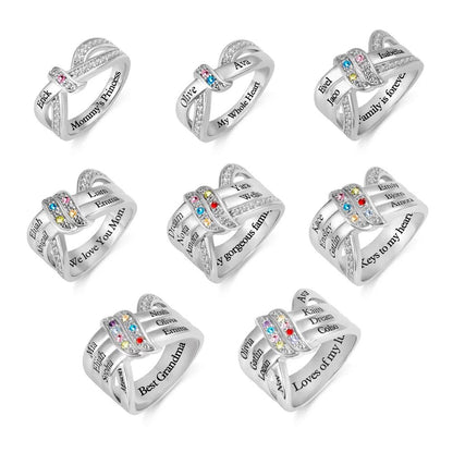 Eight silver intertwined rings with engraved names and colorful gemstones, featuring phrases like "My Whole Heart," "Family is forever," and "Best Grandma."