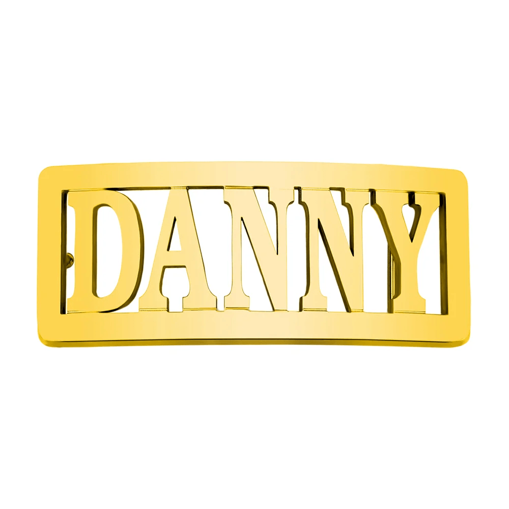 Rectangular gold belt buckle with 'DANNY' in bold uppercase letters, cut through the metal, isolated on a white background.