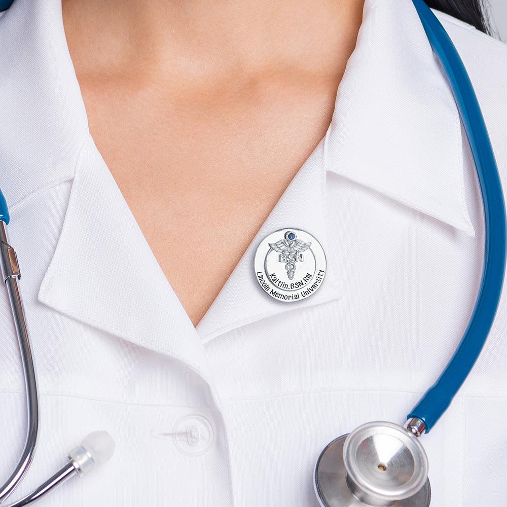 Nursing pin on white coat lapel with blue stethoscope.