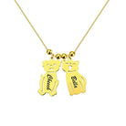 A gold necklace with two pendants shaped like a dog and a cat. The dog pendant is engraved with "Cheech" and the cat pendant with "Bella."