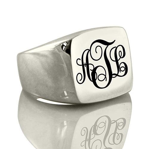 A silver signet ring with a polished rectangular face, engraved with the initials "ATL" in an elegant, cursive monogram style.