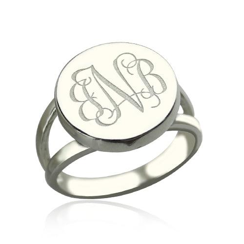 A silver ring with a semi-split shank band, featuring an oval-shaped face engraved with elegant, intertwined initials "ENB" in a cursive script, giving it an elegant and distinctive appearance.