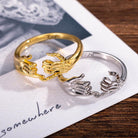 Gold and Silver Pinky Promise Rings Resting on Paper Marked 'somewhere