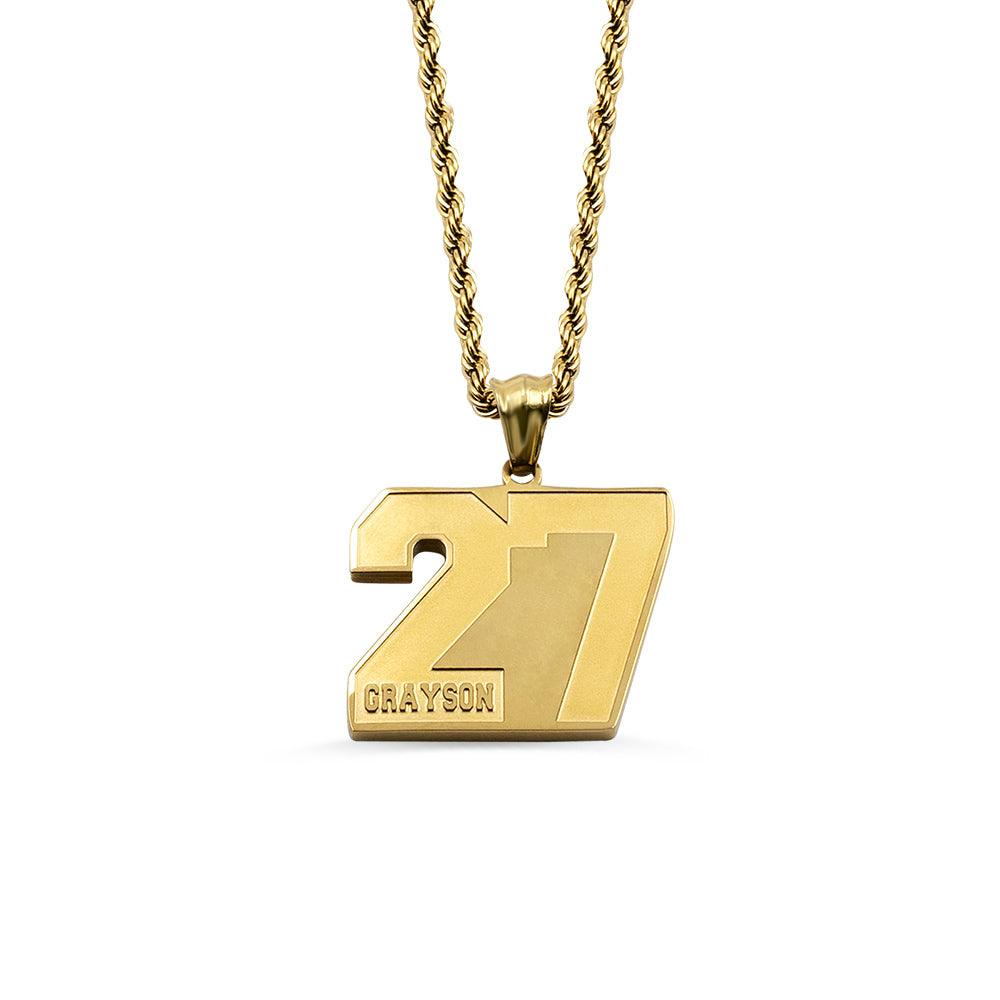 A gold pendant with the number 27 and the name "Grayson" engraved on it, hanging from a gold chain, isolated on a white background.