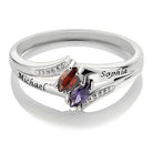 Silver ring with marquise-cut red and purple stones, engraved with "Michael" and "Sophia" on the sides. The band features small embedded diamonds on both sides.