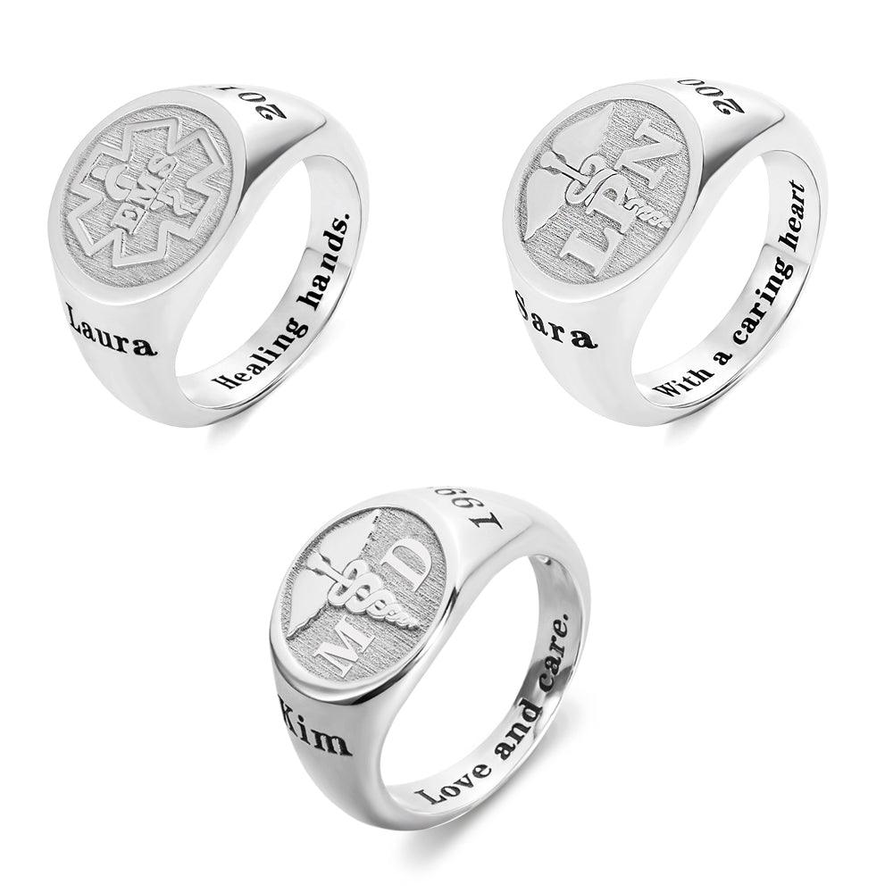 Three silver rings with engraved designs: "CNA," "RN," "MD," caduceus symbols, "2021," "667," "Laura," "Sara," "Kim," and phrases like "Healing hands," "With a caring heart," and "Love and care.