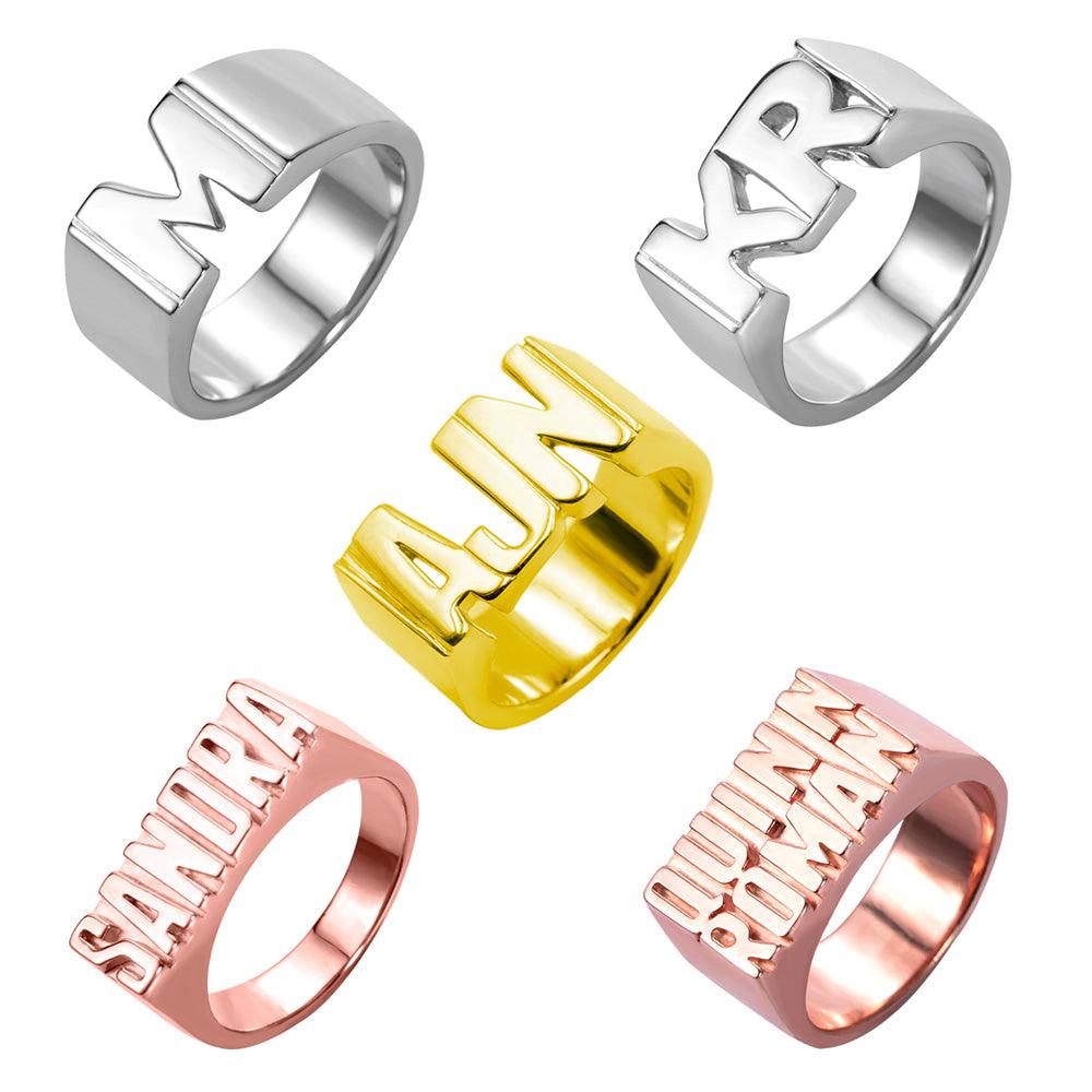 Custom name rings in various styles and finishes including silver, gold, and rose gold, featuring personalized initials and full names like Sandra and Quinn Roman.