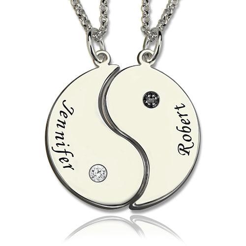 A yin-yang necklace split into two halves, each with a name engraved ("Jennifer" on the left and "Robert" on the right), a gemstone, and separate chains.