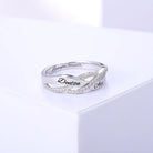 A silver infinity ring with diamond accents, engraved with the names "Denton" and "Alex" on the outer band and "Love you forever" on the inner band, displayed on a white surface.